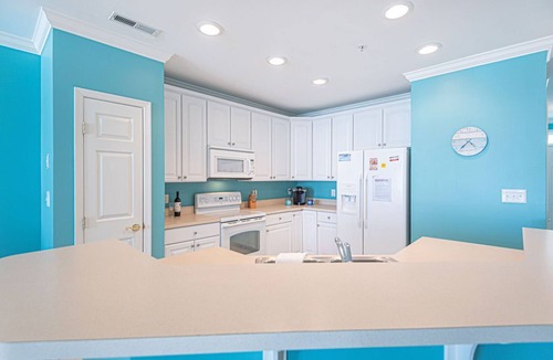 Sunset Island Condo | Bright, modern 3-bedroom luxury condo in gated community, free WiFi, private bayside beaches, an indoor and outdoor pool, and more located midtown and a couple blocks to the ocean!